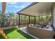 The backyard features a covered patio, artificial turf and lounge seating at 2452 Silver Shadow Dr, Las Vegas, NV 89108