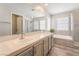 Bright bathroom featuring double sinks, a soaking tub and a glass-enclosed shower at 2452 Silver Shadow Dr, Las Vegas, NV 89108