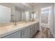 Bright bathroom with double sinks, tile countertops, and a view of the shower/tub at 2452 Silver Shadow Dr, Las Vegas, NV 89108
