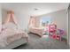 Charming bedroom featuring two beds with crown canopies, a window view, and dollhouse at 2452 Silver Shadow Dr, Las Vegas, NV 89108