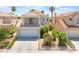 Attractive two-story home featuring a balcony, two-car garage, complemented by lush landscaping and mature palm trees at 2452 Silver Shadow Dr, Las Vegas, NV 89108