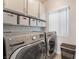 Laundry room with stainless steel washer and dryer, shelving, and a window at 2452 Silver Shadow Dr, Las Vegas, NV 89108