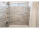 Elegant shower with modern gray tile, pebble accents, and a rainfall shower head at 2452 Silver Shadow Dr, Las Vegas, NV 89108