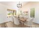 Dining room with wood floors, lots of natural light, and a table set for six, virtually staged at 2505 Showcase Dr, Las Vegas, NV 89134
