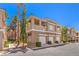 Exterior view of condos featuring attached garages, multiple balconies, and a beautifully landscaped community at 251 S Green Valley Pkwy # 1421, Henderson, NV 89012