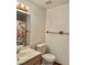 This bathroom has a white toilet and sink with modern fixtures, and a floral shower curtain at 2621 Blue Reef Dr, North Las Vegas, NV 89032