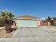 Exterior view of a tan single-story home with a large garage and desert landscaping at 2621 Blue Reef Dr, North Las Vegas, NV 89032