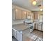 Well-lit kitchen featuring tile flooring, light wood cabinetry, and modern appliances at 2621 Blue Reef Dr, North Las Vegas, NV 89032