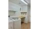 This laundry room has a laundry machine, hanging shelves, and a wooden countertop at 2621 Blue Reef Dr, North Las Vegas, NV 89032