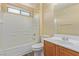 Bright bathroom features a shower-tub combo, wooden vanity and a large framed mirror at 3037 Austin Pale Ave, North Las Vegas, NV 89081