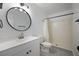 Modern bathroom with white vanity, updated fixtures, round mirror, and walk-in shower at 3151 Soaring Gulls Dr # 2121, Las Vegas, NV 89128