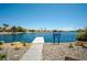 Waterfront view featuring a dock and community sign with water and palm trees at 3151 Soaring Gulls Dr # 2121, Las Vegas, NV 89128