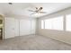 Bright bedroom with neutral carpet, a ceiling fan, and large windows with lots of natural light at 3209 Cheltenham St, Las Vegas, NV 89129
