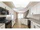 Modern kitchen with granite counters, white cabinets, stainless-steel appliances, and open to the dining area at 3209 Cheltenham St, Las Vegas, NV 89129
