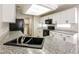 Updated kitchen with granite countertops, white cabinets, and modern stainless-steel appliances at 3209 Cheltenham St, Las Vegas, NV 89129