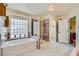 Bathroom showcasing soaking tub, glass block window, and walk-in shower with gold trim at 3231 Rebel Ave, Pahrump, NV 89048