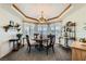 Elegant dining room with a chandelier, bay windows with shutters, and stylish furnishings for a sophisticated dining experience at 3231 Rebel Ave, Pahrump, NV 89048
