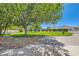 View of a home with a well-manicured lawn, framed by mature trees and manicured shrubbery and a brick paved driveway at 3231 Rebel Ave, Pahrump, NV 89048
