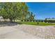 View of a home with a well-manicured lawn, framed by mature trees and manicured shrubbery and a brick paved driveway at 3231 Rebel Ave, Pahrump, NV 89048