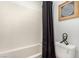 Bathroom with a white tiled shower/tub and a black shower curtain, next to toilet and artwork at 328 Owens Peak Dr, Henderson, NV 89015