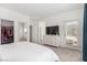 Bright bedroom featuring a walk-in closet, access to balcony, and a white dresser with mounted TV at 328 Owens Peak Dr, Henderson, NV 89015