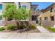 Eye-catching townhome featuring a stone accent wall, lush landscaping, and a secure gated entrance at 328 Owens Peak Dr, Henderson, NV 89015