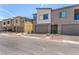 Exterior view of townhomes with gray facade, landscaping, and private garages at 328 Owens Peak Dr, Henderson, NV 89015
