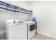 Bright laundry room with washer, dryer, storage and tile floors at 328 Owens Peak Dr, Henderson, NV 89015