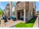 Inviting patio with comfortable outdoor furniture, manicured artificial grass, and a stone-accented facade at 328 Owens Peak Dr, Henderson, NV 89015