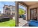 Cozy covered patio with stylish outdoor seating, a small lawn, and views of the townhome's architecture at 328 Owens Peak Dr, Henderson, NV 89015