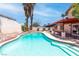 Backyard oasis with a large swimming pool, mature palm trees, and a covered patio area for relaxing and entertaining at 3793 Casa Colorado Ave, Las Vegas, NV 89121