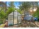 A bright greenhouse, perfect for gardening enthusiasts, sits in a sunny spot surrounded by trees at 3971 Arlberg Way, Mount Charleston, NV 89124