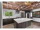 Modern kitchen features an island with granite countertops, dark cabinets, and stainless steel appliances at 3971 Arlberg Way, Mount Charleston, NV 89124