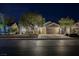 Exterior shot of home with three car garage and mature landscaping at night at 4065 Genoa Dr, Las Vegas, NV 89141