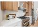 This kitchen features modern appliances, wood cabinets, and stone countertops with a subway tile backsplash at 4065 Genoa Dr, Las Vegas, NV 89141