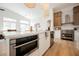 This kitchen features stone countertops, modern appliances, modern lighting, and an island with bar stool seating at 4065 Genoa Dr, Las Vegas, NV 89141