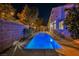 Backyard showcasing rectangular swimming pool with patio and privacy wall at night at 4065 Genoa Dr, Las Vegas, NV 89141