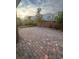 Brick paver patio and stone landscaping in a private backyard surrounded by desert flora and a block wall at 4108 Fairywren Dr, North Las Vegas, NV 89031