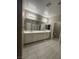 Spacious bathroom with dual sinks, a large mirror, tiled floors, and multiple doorways at 4108 Fairywren Dr, North Las Vegas, NV 89031