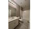 Bathroom featuring a vanity with sink, white cabinetry, a toilet, and a shower-tub combo with white tile surround at 4108 Fairywren Dr, North Las Vegas, NV 89031