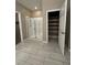 Bright bathroom featuring a glass-enclosed shower, tiled floor, and access to a large closet with shelving at 4108 Fairywren Dr, North Las Vegas, NV 89031