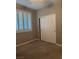 Bedroom with carpet flooring, a window with bright white shutters, and a sliding closet with mirrored doors at 4108 Fairywren Dr, North Las Vegas, NV 89031