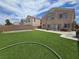 Green backyard with artificial turf, patio area, and metal archway offering plenty of outdoor space at 412 Orchid Oasis Ave, North Las Vegas, NV 89031
