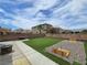 Wide backyard with low-maintenance artificial turf, stone fire pit and built-in horseshoe pits at 412 Orchid Oasis Ave, North Las Vegas, NV 89031
