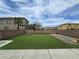 Spacious backyard with artificial turf, rock area and brick perimeter wall offering privacy at 412 Orchid Oasis Ave, North Las Vegas, NV 89031