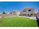 Expansive backyard featuring a lush lawn, block wall fencing, and patio area at 412 Orchid Oasis Ave, North Las Vegas, NV 89031