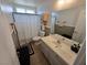 This bathroom boasts a modern vanity, tiled floors, and a shower with a black and white patterned curtain at 412 Orchid Oasis Ave, North Las Vegas, NV 89031