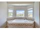 Relaxing bathtub with a large window, tile surround, and neighborhood views at 412 Orchid Oasis Ave, North Las Vegas, NV 89031