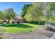 Manicured community area with green grass, landscaping, bushes, and trees at 412 Orchid Oasis Ave, North Las Vegas, NV 89031