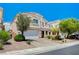 Two-story home featuring a paved driveway, two-car garage, and desert landscaping at 412 Orchid Oasis Ave, North Las Vegas, NV 89031